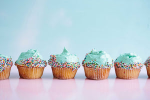 Row of cupcakes on a blue background. 